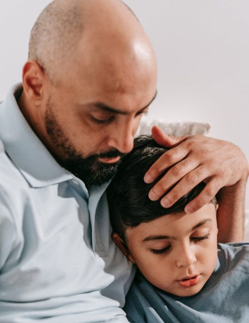 A touching scene of a father lovingly embracing his son, capturing the essence of family bonds.